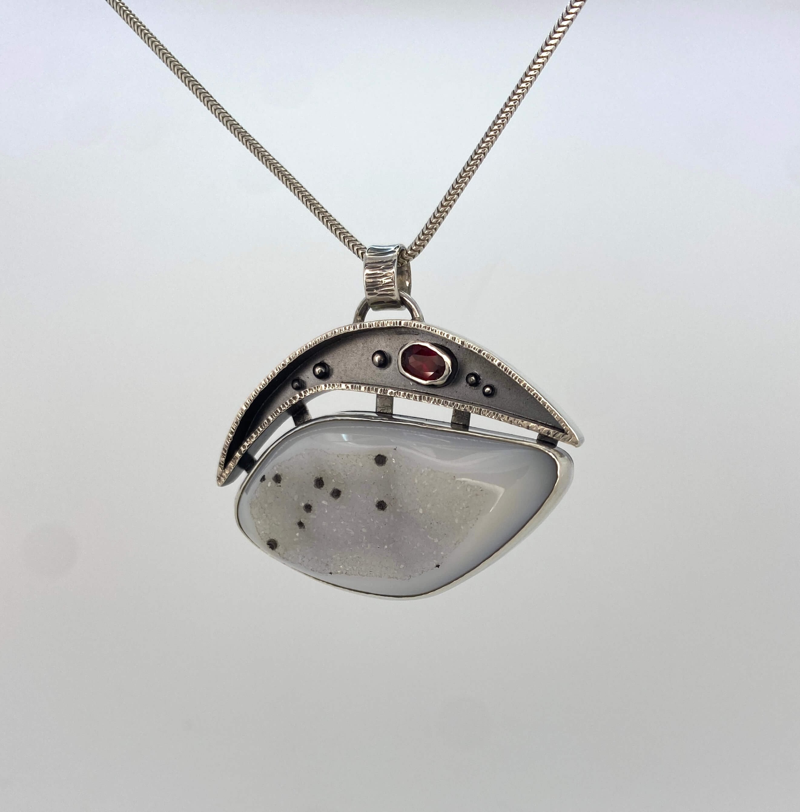 White druzy quartz with black spots and garnet_front view