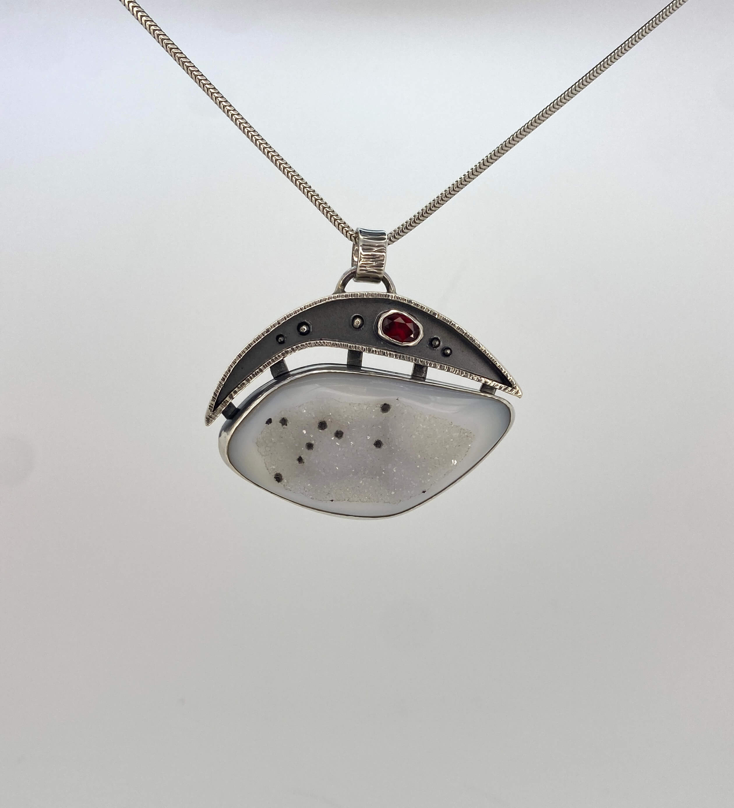 White druzy quartz with black spots and garnet_front view