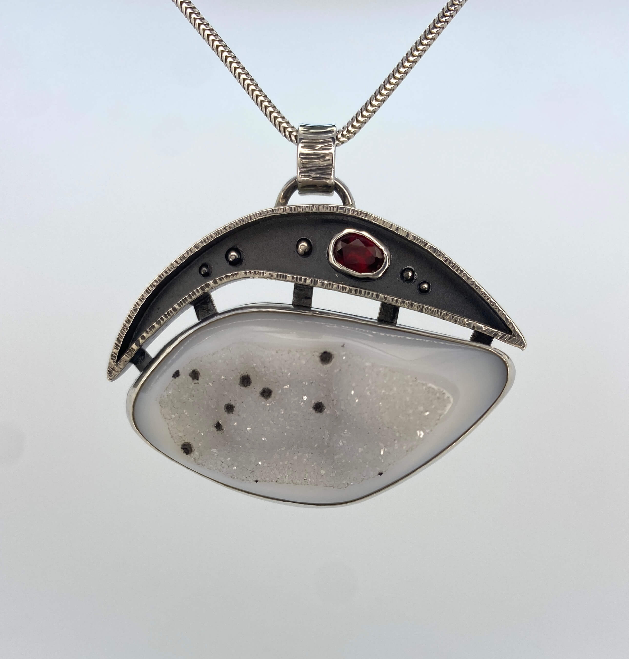White druzy quartz with black spots and garnet_front view